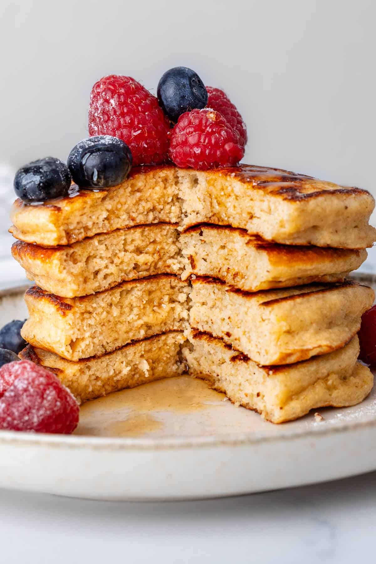 Stack of Greek yogurt pancakes with a piece missing to show the inside
