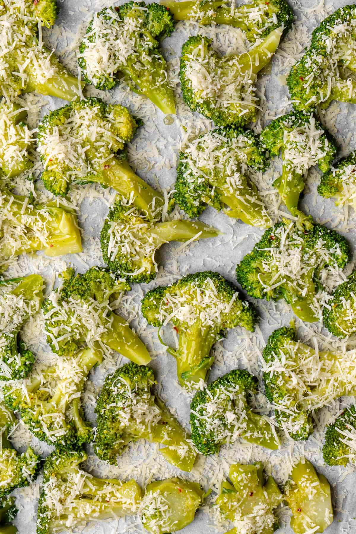 Broccoli florets on an oven tray with parmesan cheese before being baked
