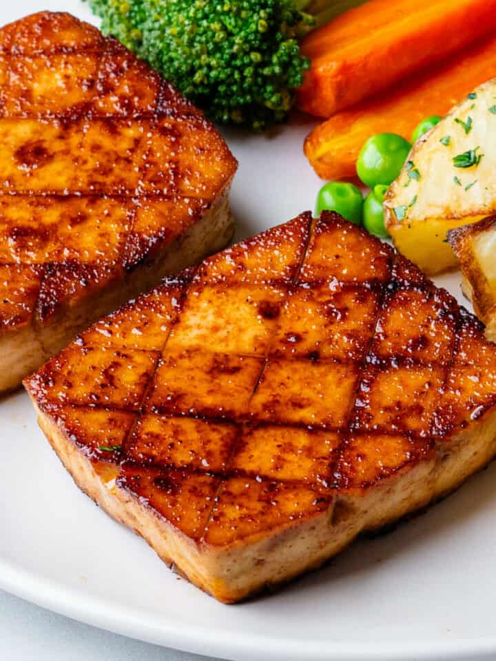 Tofu steak served with a side of vegetables