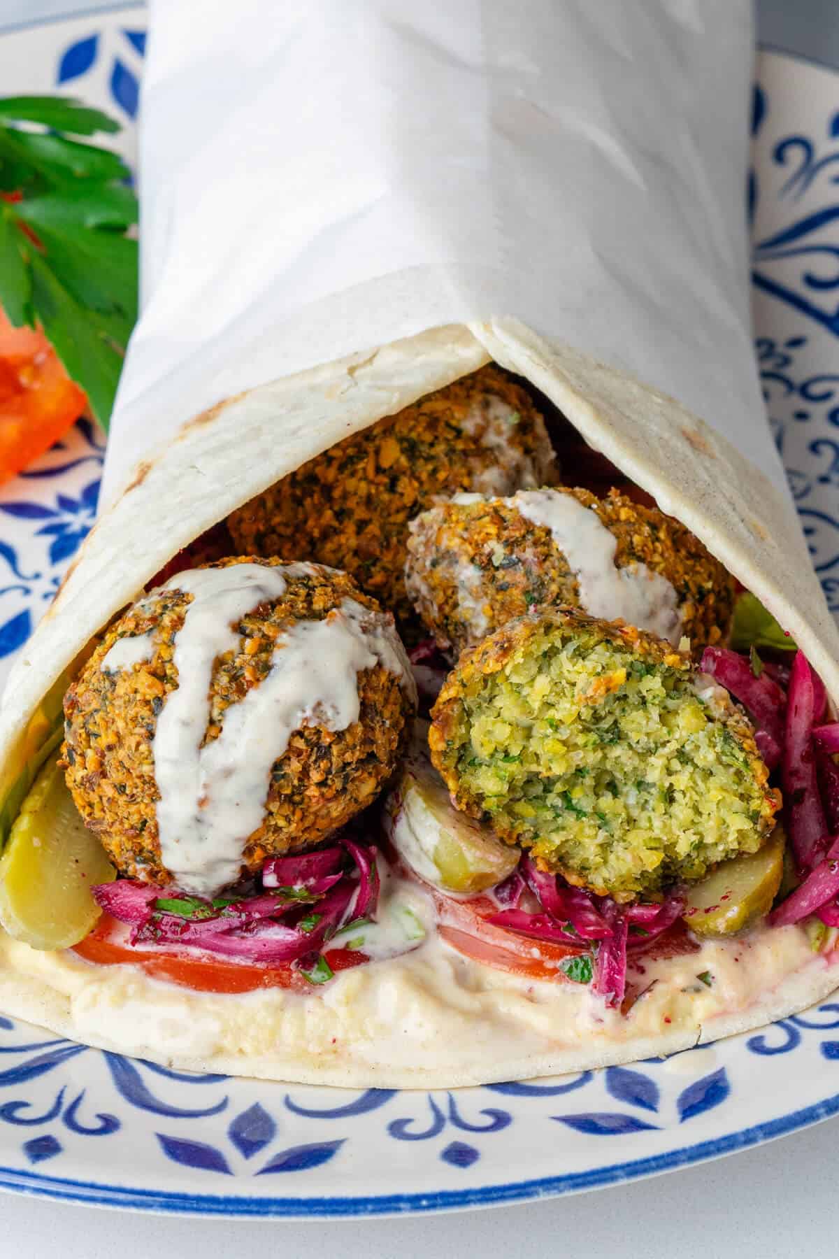 Falafel wrap with piece cut in half to show the inside