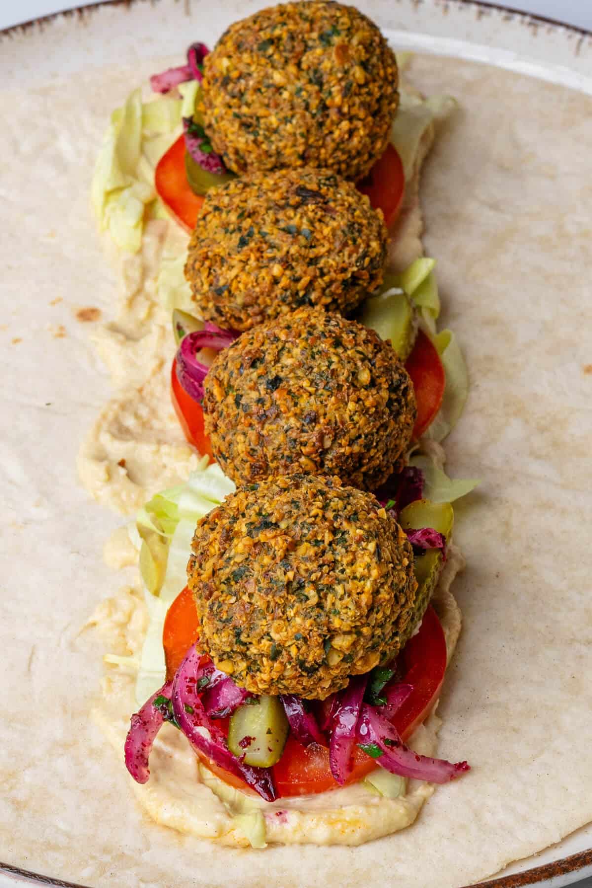 Falafel balls placed on top of filling and wrap