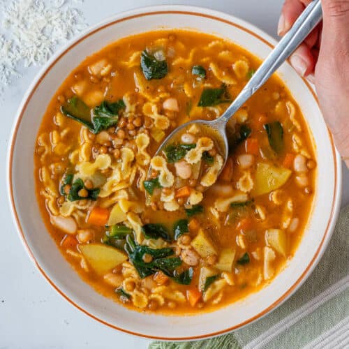 Italian minestrone soup with a spoon coming out of the bowl