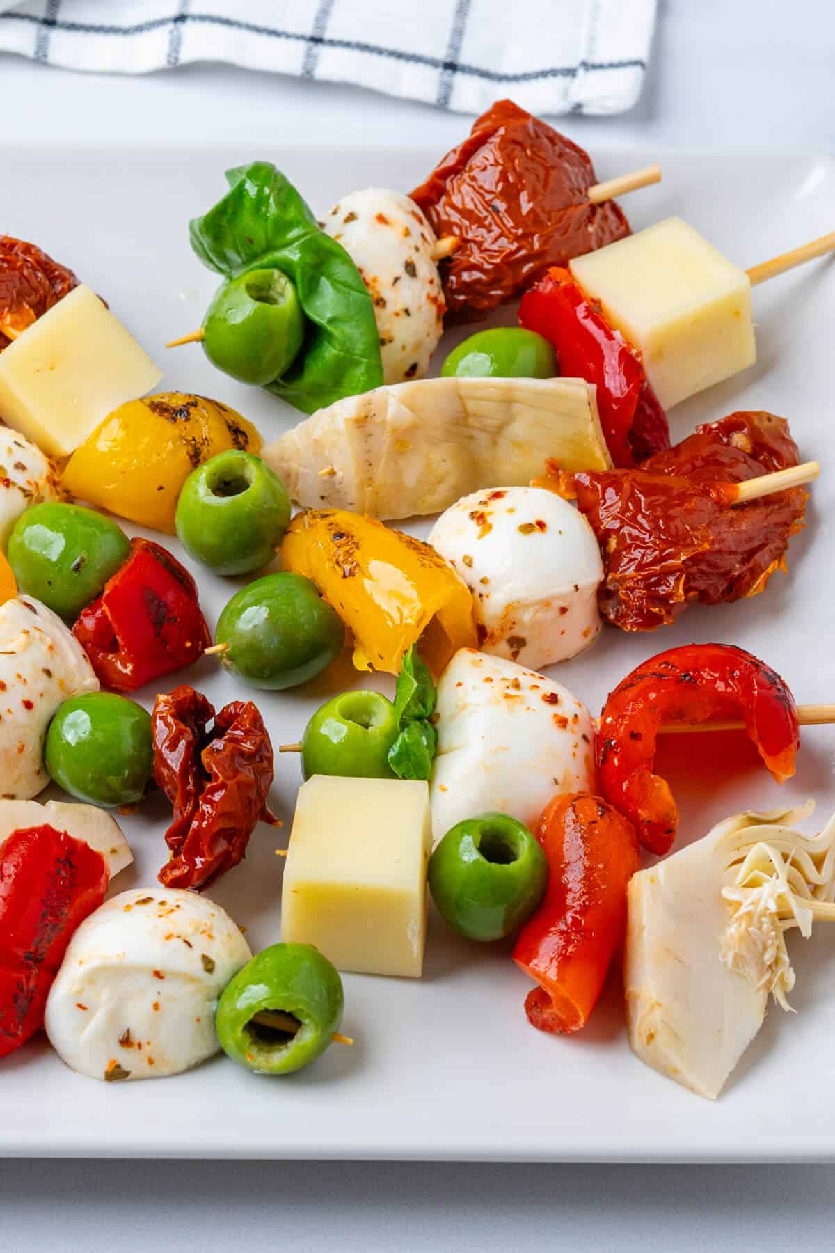 Antipasto skewers with a mix of cheese, red peppers, olive, sun dried tomatoes and artichokes