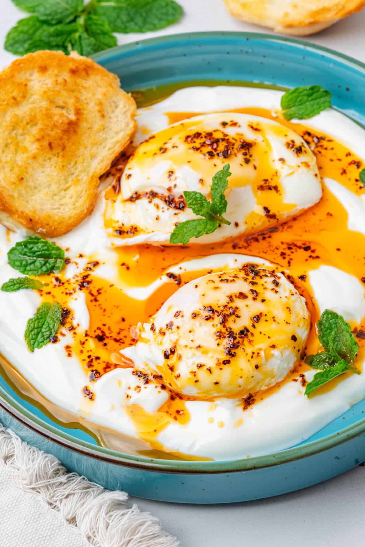 Cilbir turkish eggs with aleppo pepper oil, fresh mint and toasted bread