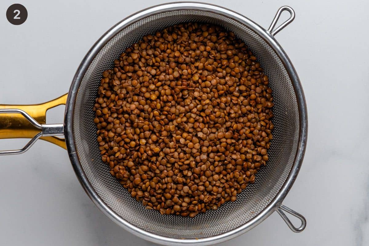 Cooked lentils being drained over the pot