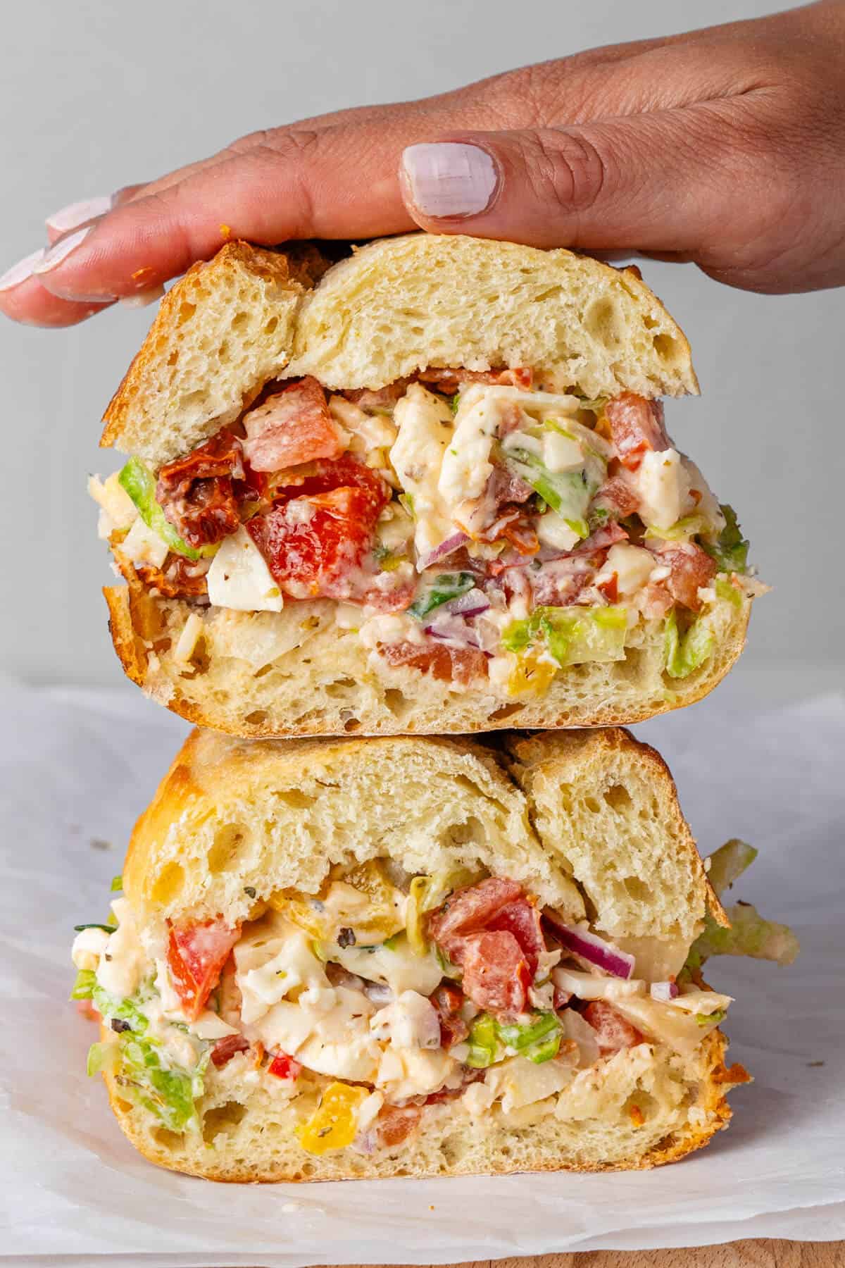 Stacked sandwich with hand on top