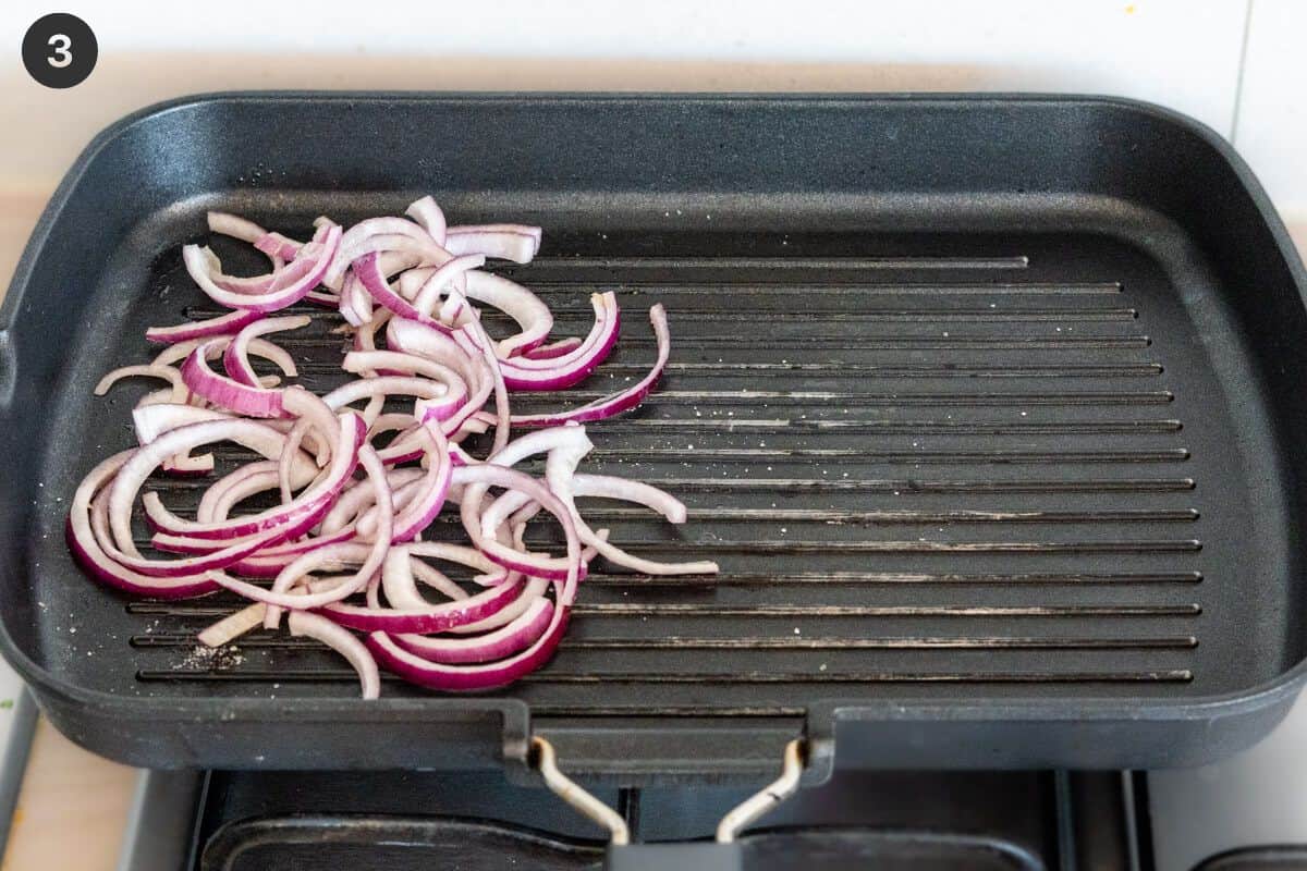 red onions being grilled on a pan