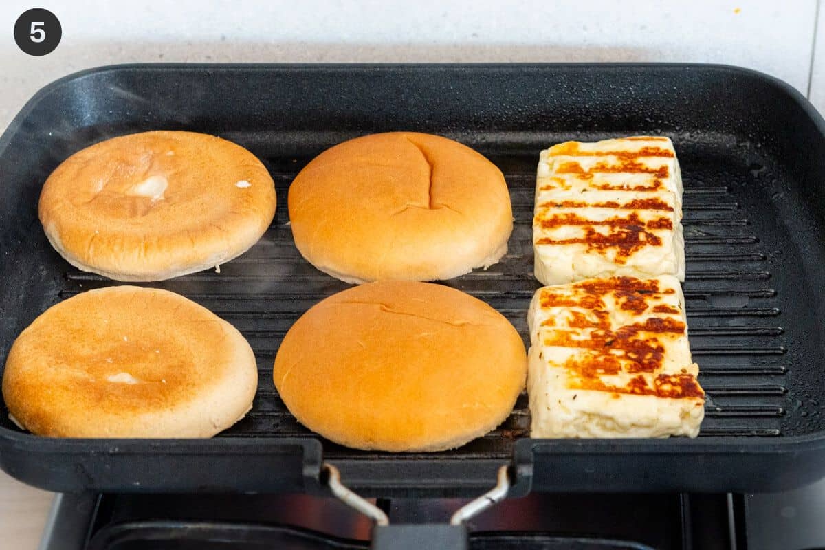 Burger buns and halloumi pieces on a grill pan