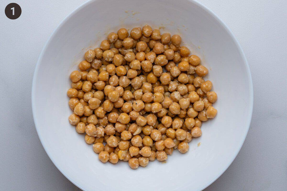 Chickpeas placed on bottom of salad bowl