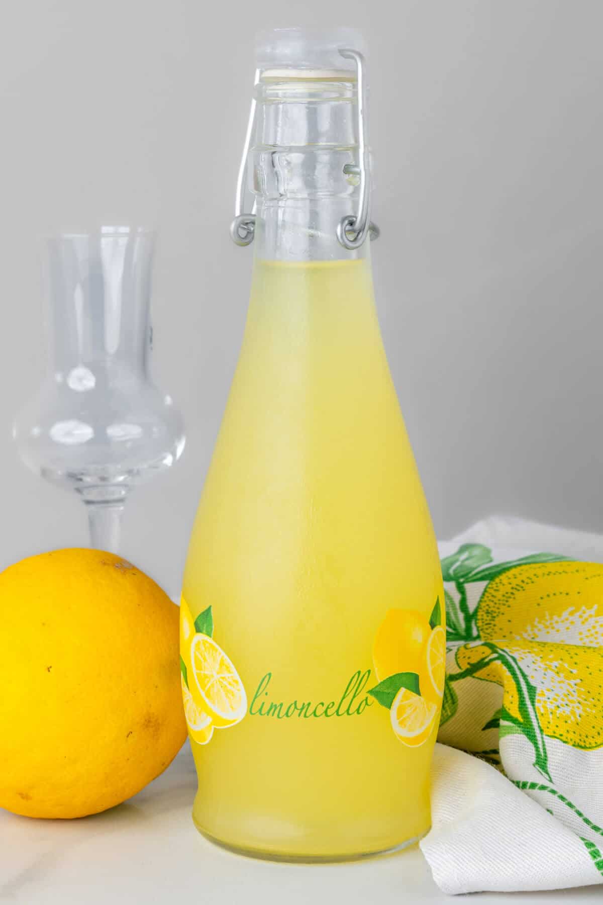 Bottle of limoncello with a glass and lemon in shot