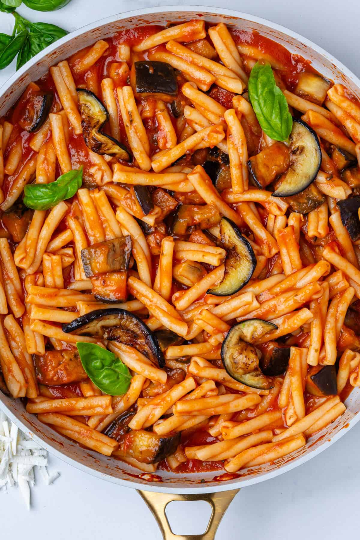 Pan full of pasta alla norma with fresh basil on top