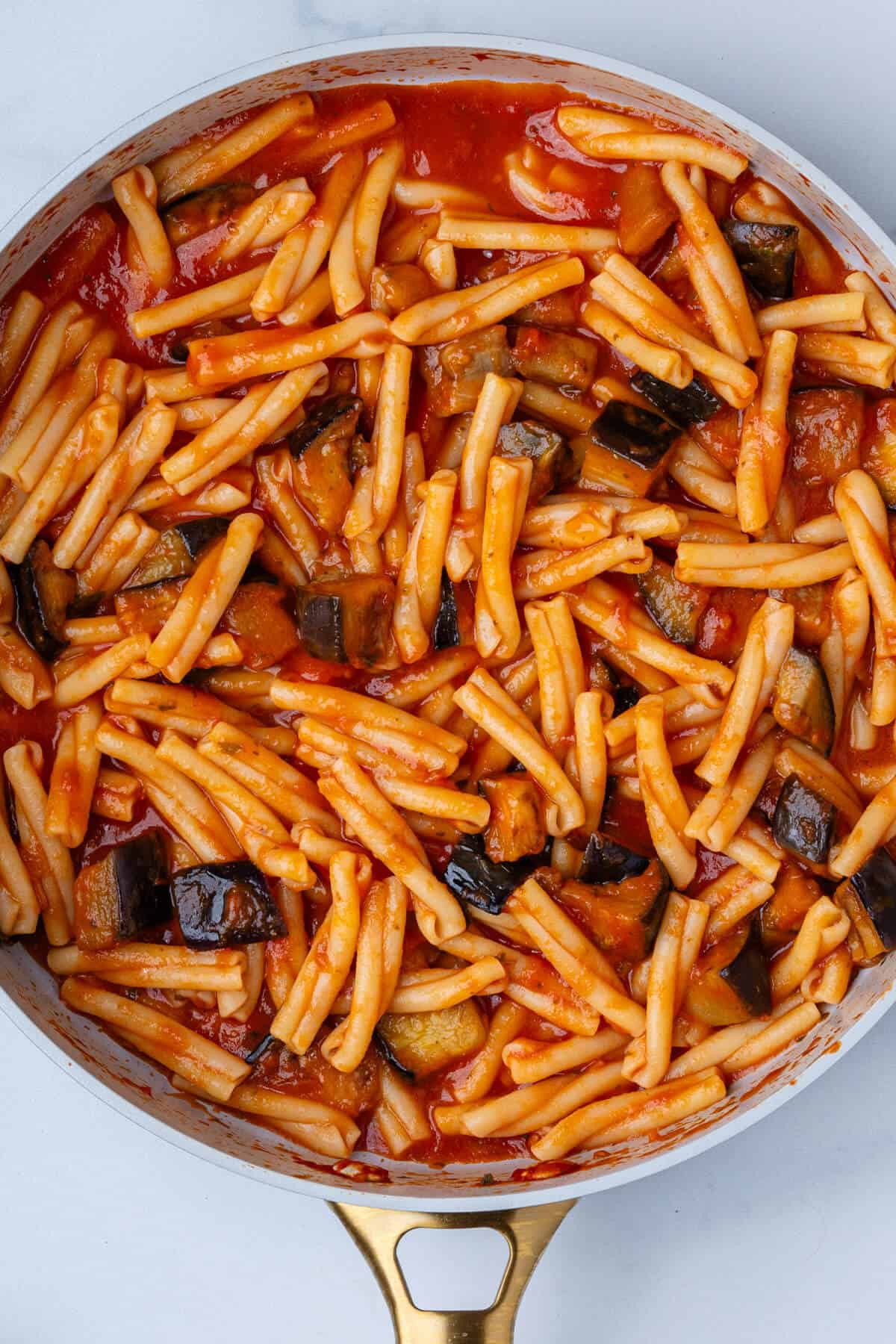 Cooked pasta with tomato sauce and eggplants in a pan