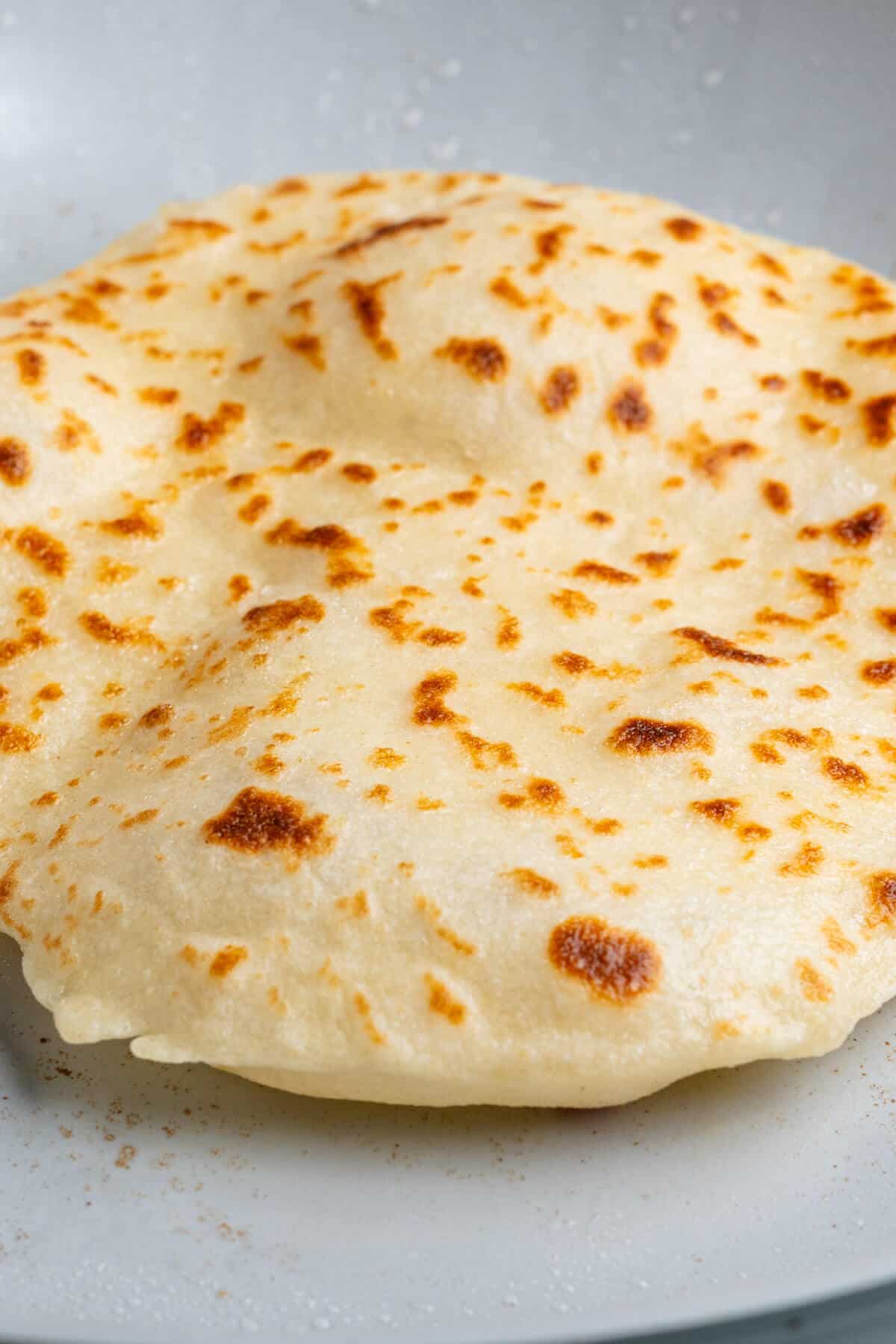 Piece of flatbread being cooked on a pan