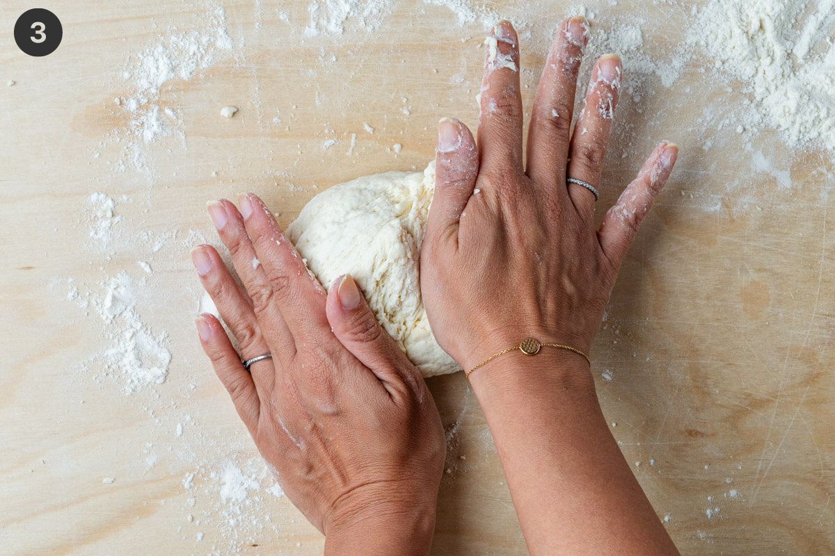 Dough being kneaded by hands
