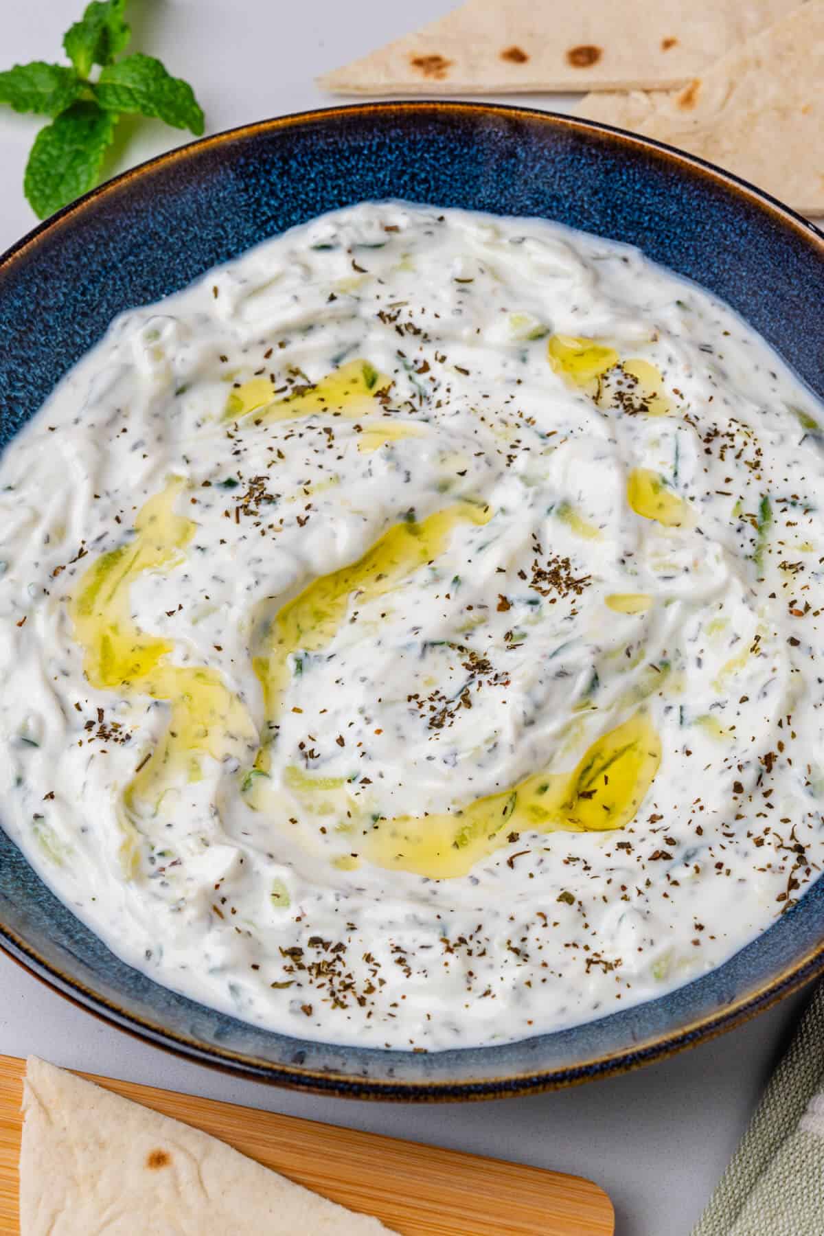 Cacik in a bowl with fresh mint and pita bread