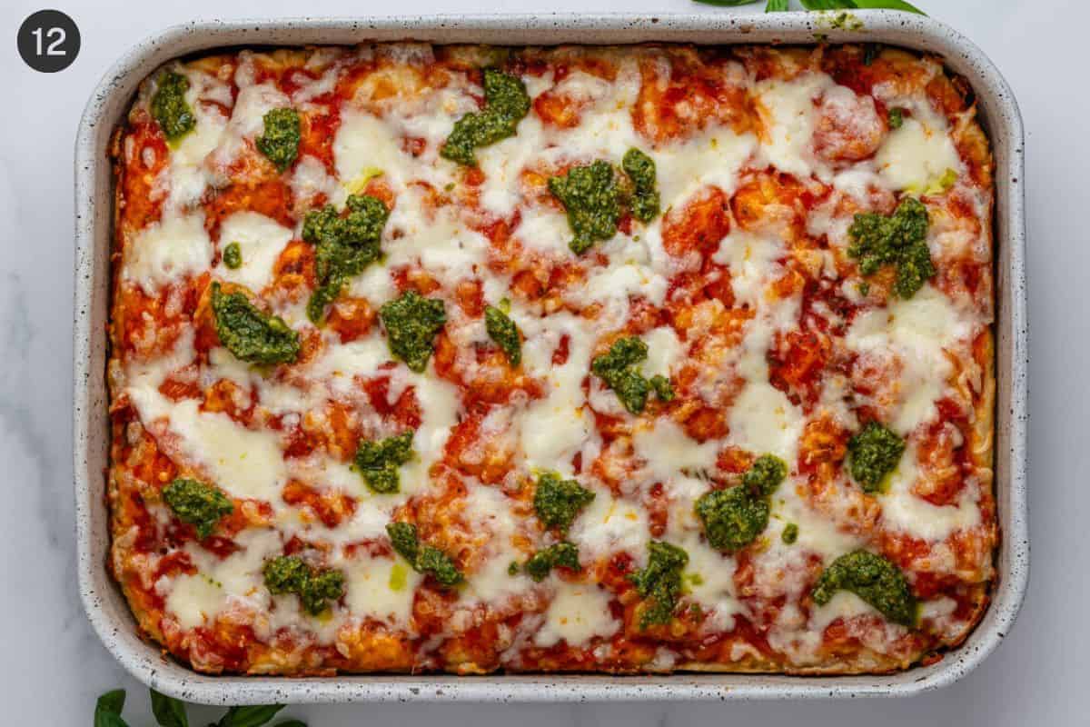 Final cooked focaccia pizza with fresh basil pesto on top