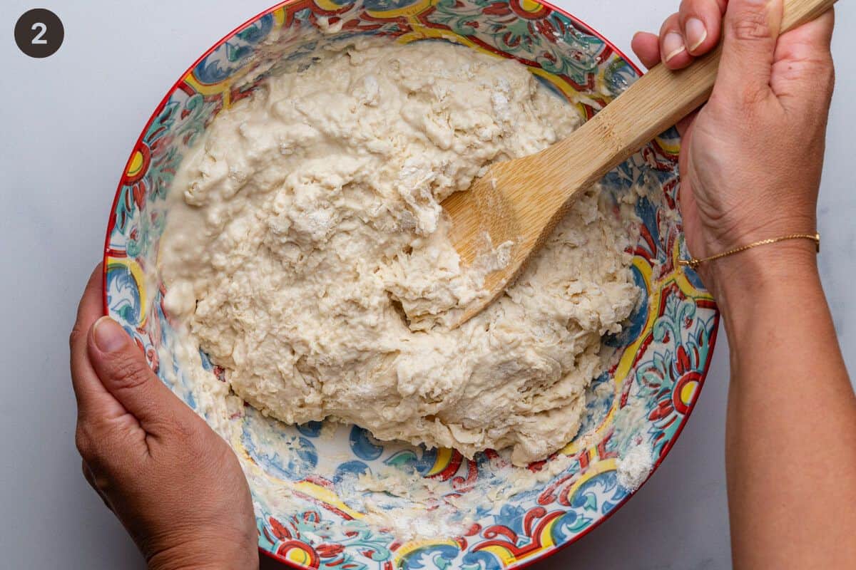 Dough being mixed in a bowl with yeast water