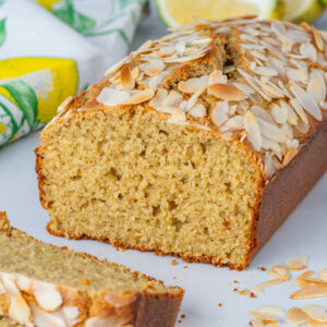 Lemon loaf cake sliced to show the inside with almond flakes