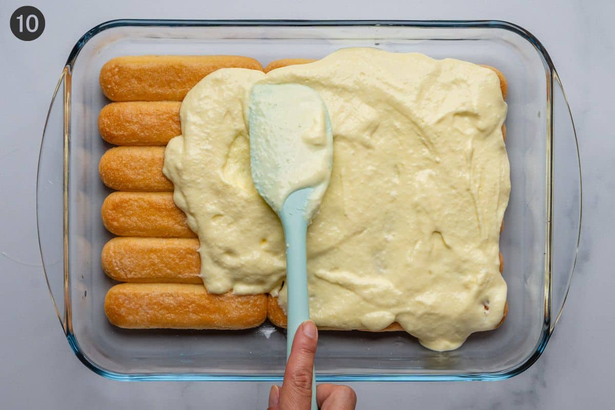 Half of the cream mixture poured on top of biscuits