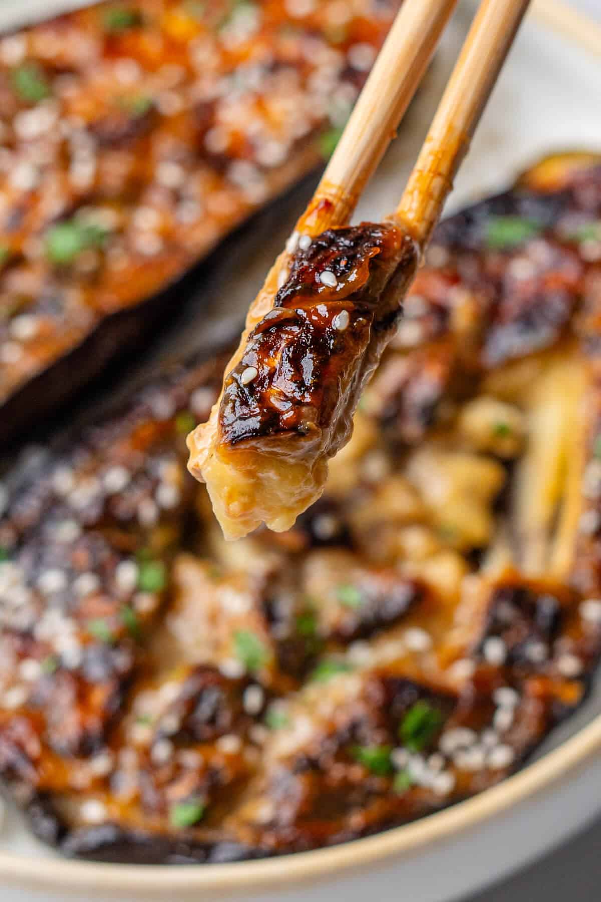 Close up of piece of eggplant in chopsticks