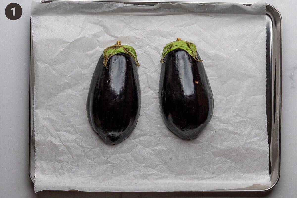 Eggplants face down on an oven tray