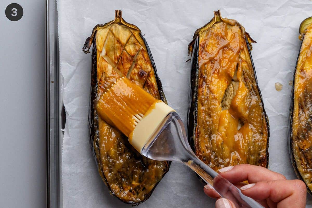 Miso paste being brushed on the flesh of eggplants