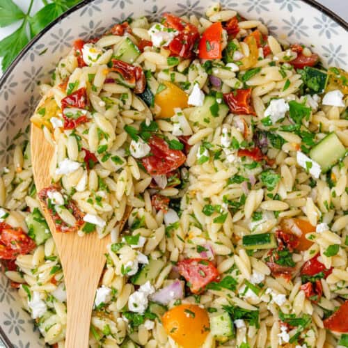 Spoon in a bowl of orzo salad