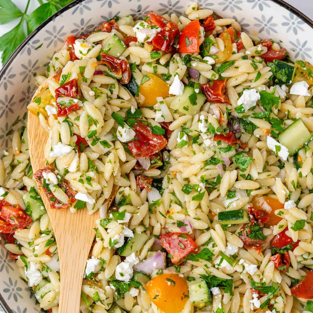 Spoon in a bowl of orzo salad