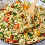 Spoon in a bowl of orzo salad