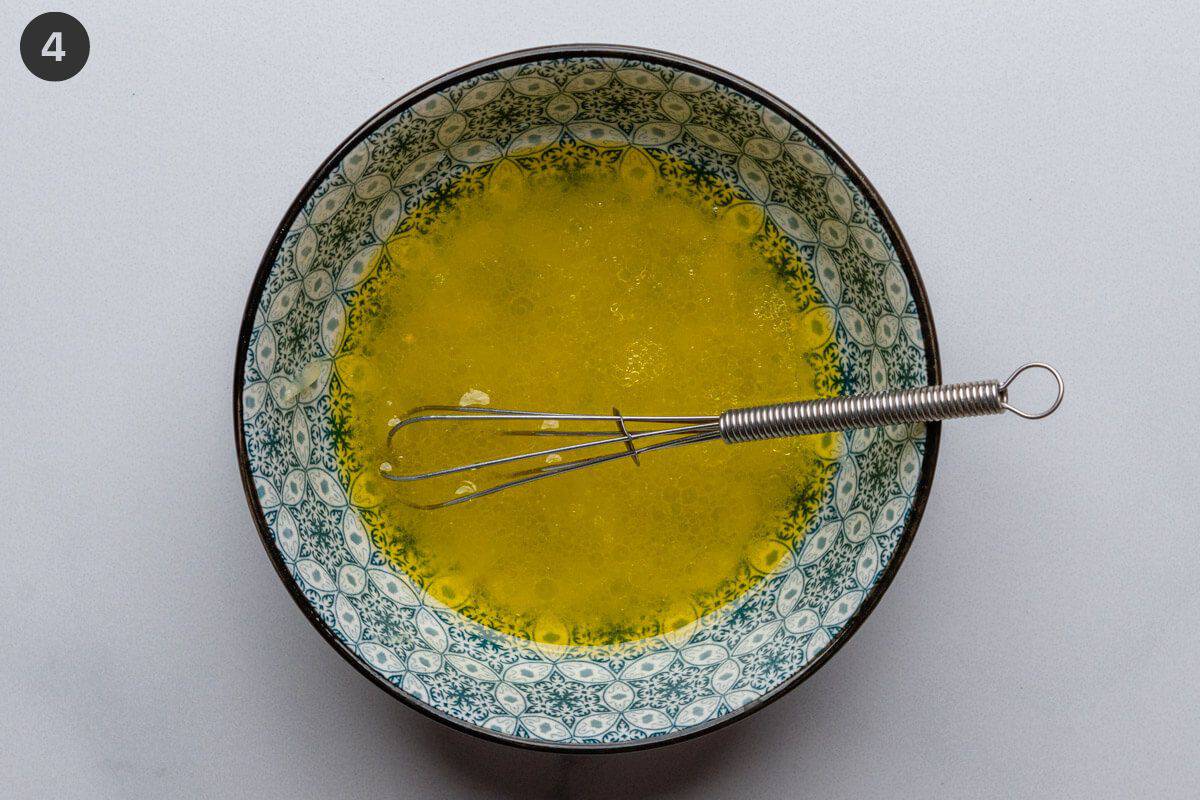 Salad dressing in a small bowl with a whisk