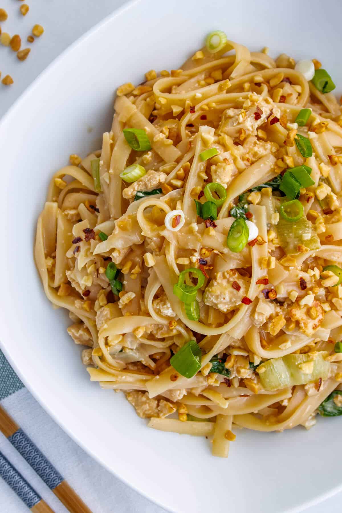Peanut noodles served with green onions and crushed peanuts