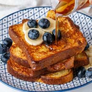 Maple syrup being poured on Brioche French Toast