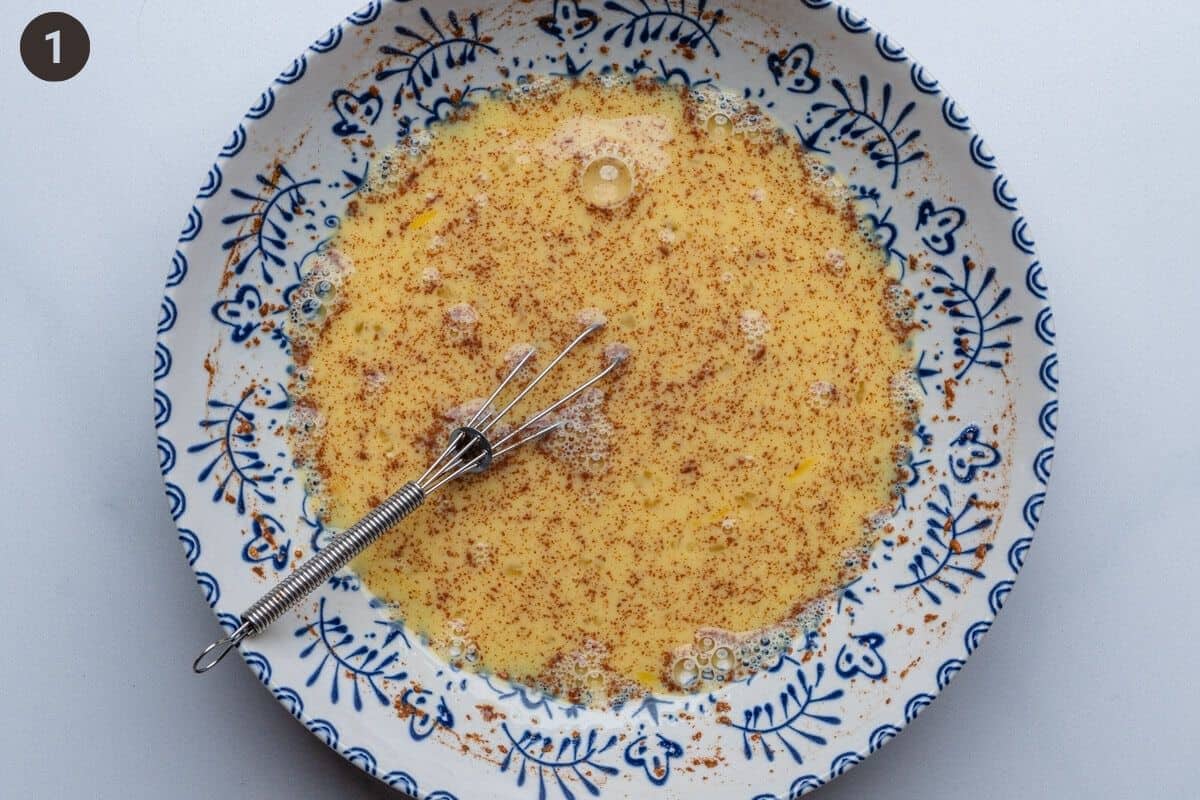 Egg mixture in a bowl with a whisk