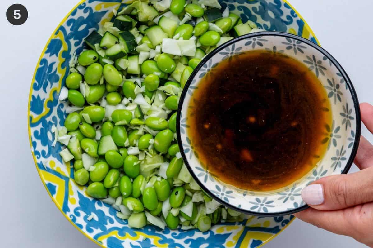 Sesame dressing being poured into salad