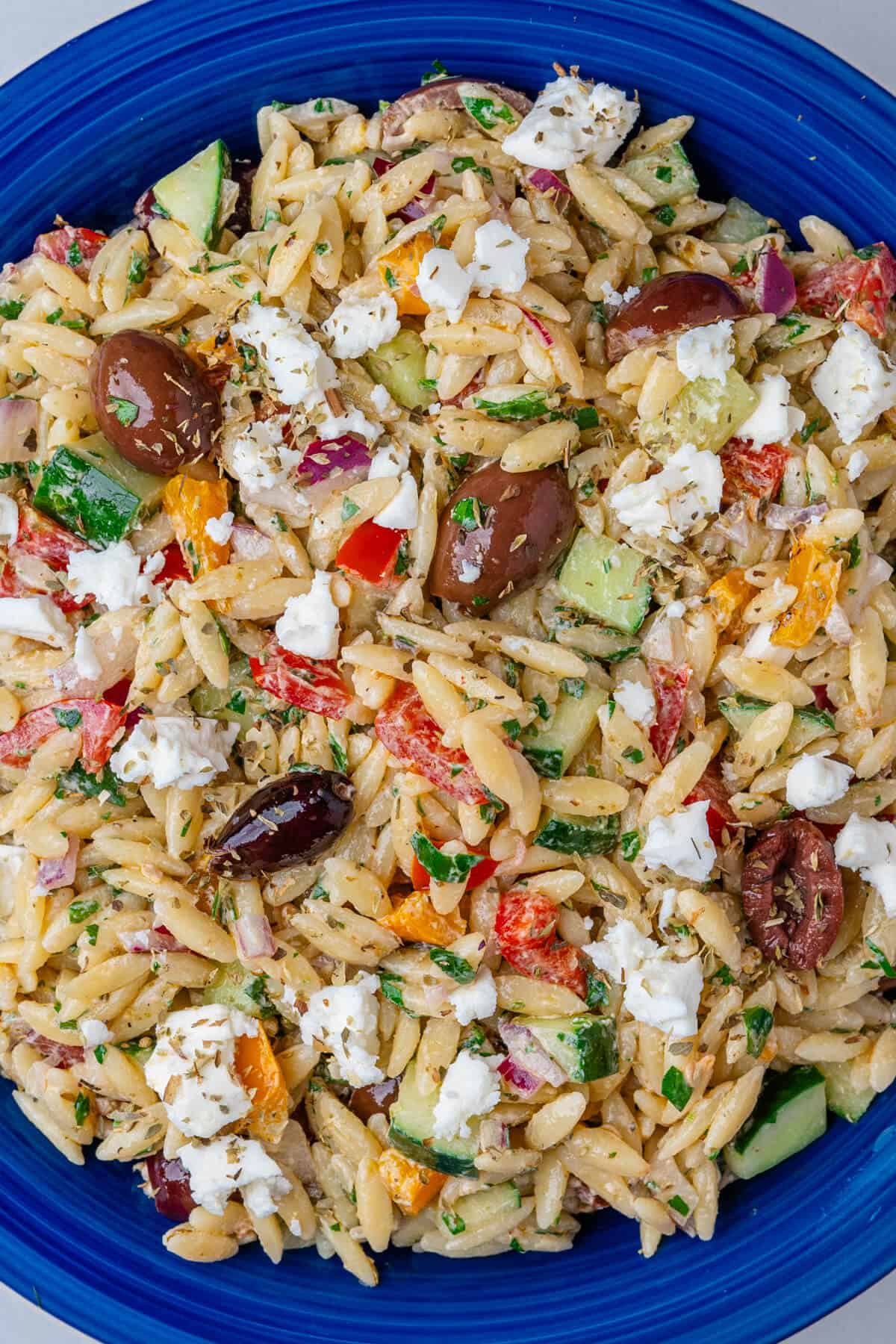 Greek orzo salad in a blue bowl