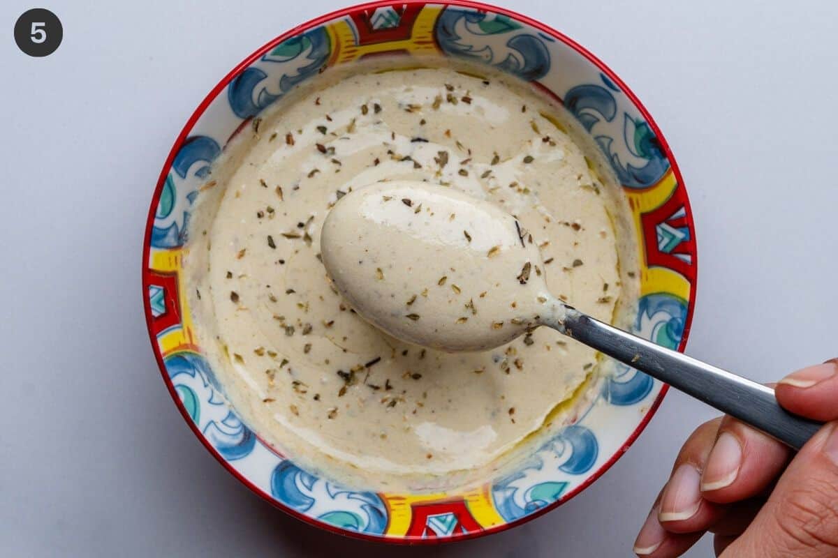 Creamy feta dressing in a bowl with a spoon