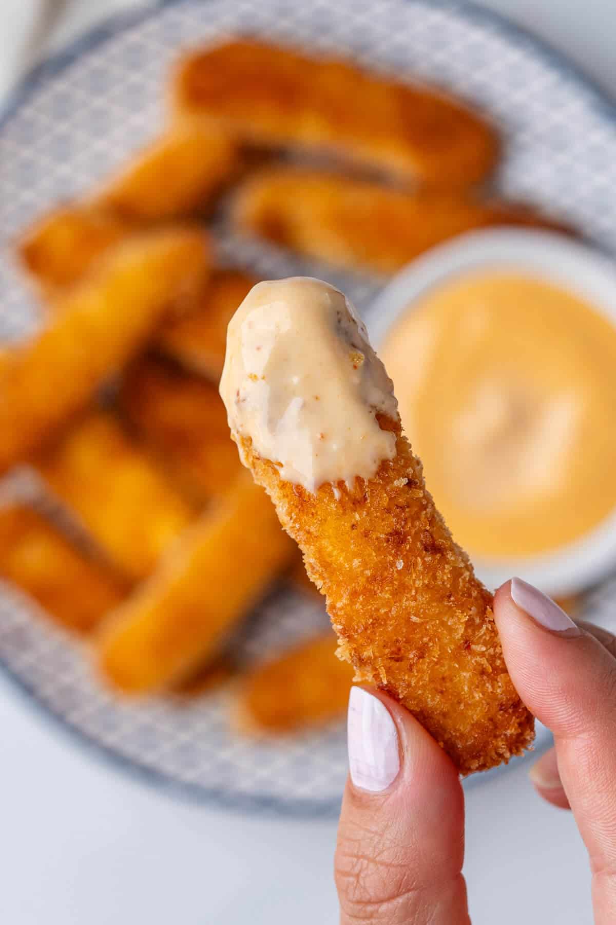 Close up of a fry that has been dipped in aioli