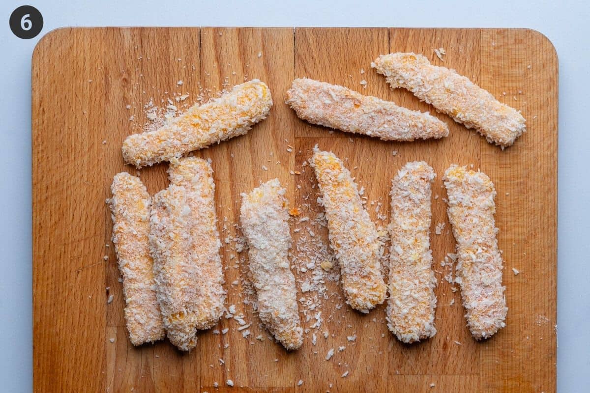 Crumbed fries on a cutting board, ready to be cooked