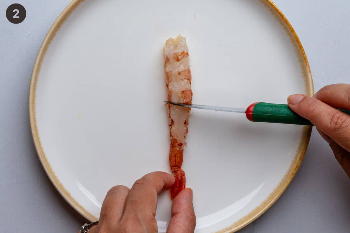 Small cuts being made on the back of a shrimp