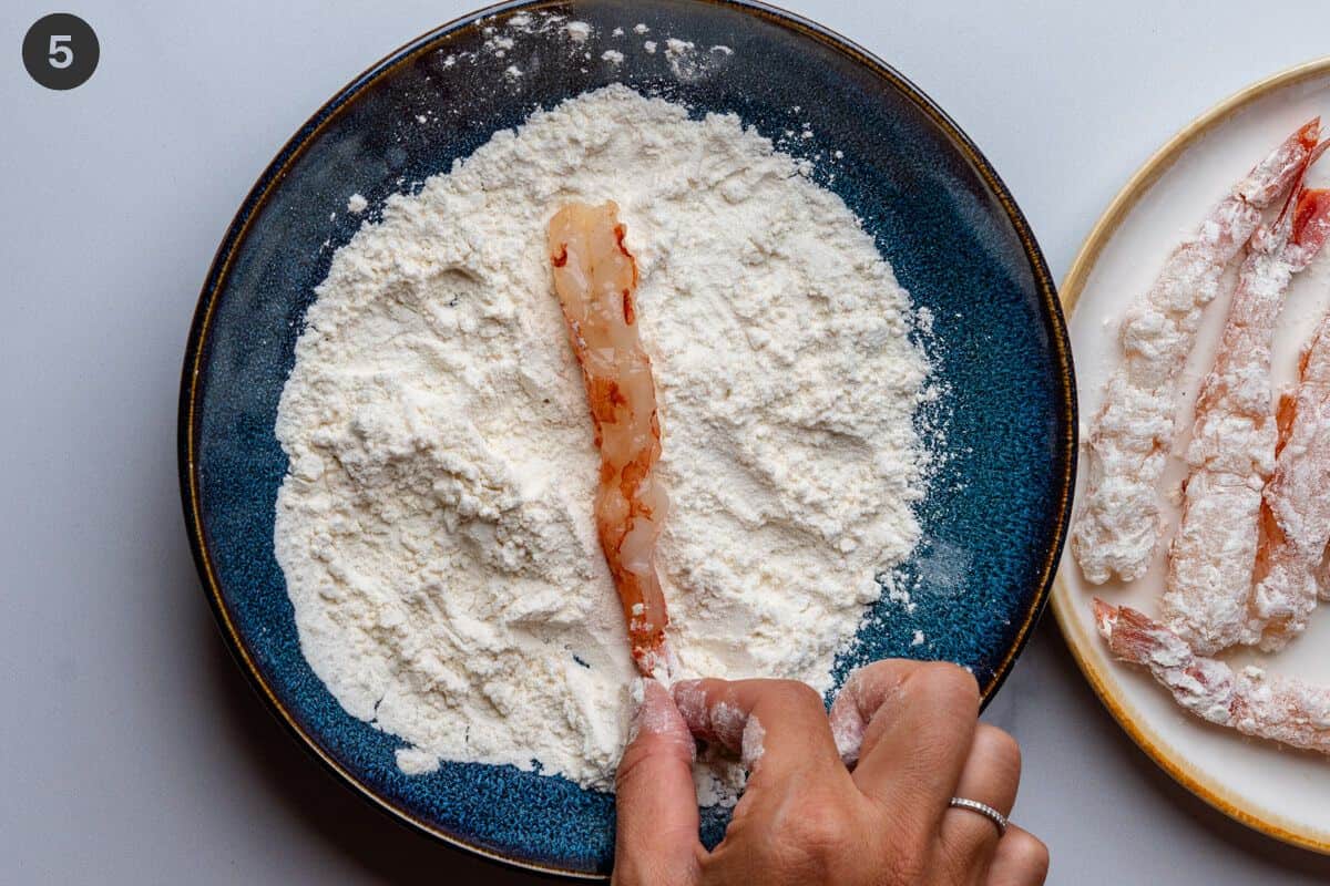 Shrimp coated in a bowl of flour