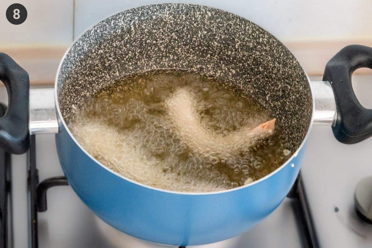 Shrimp being fried in a pot of oil