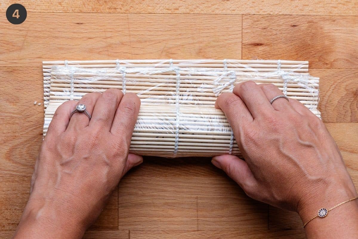 Rolling the sushi roll with bamboo mat