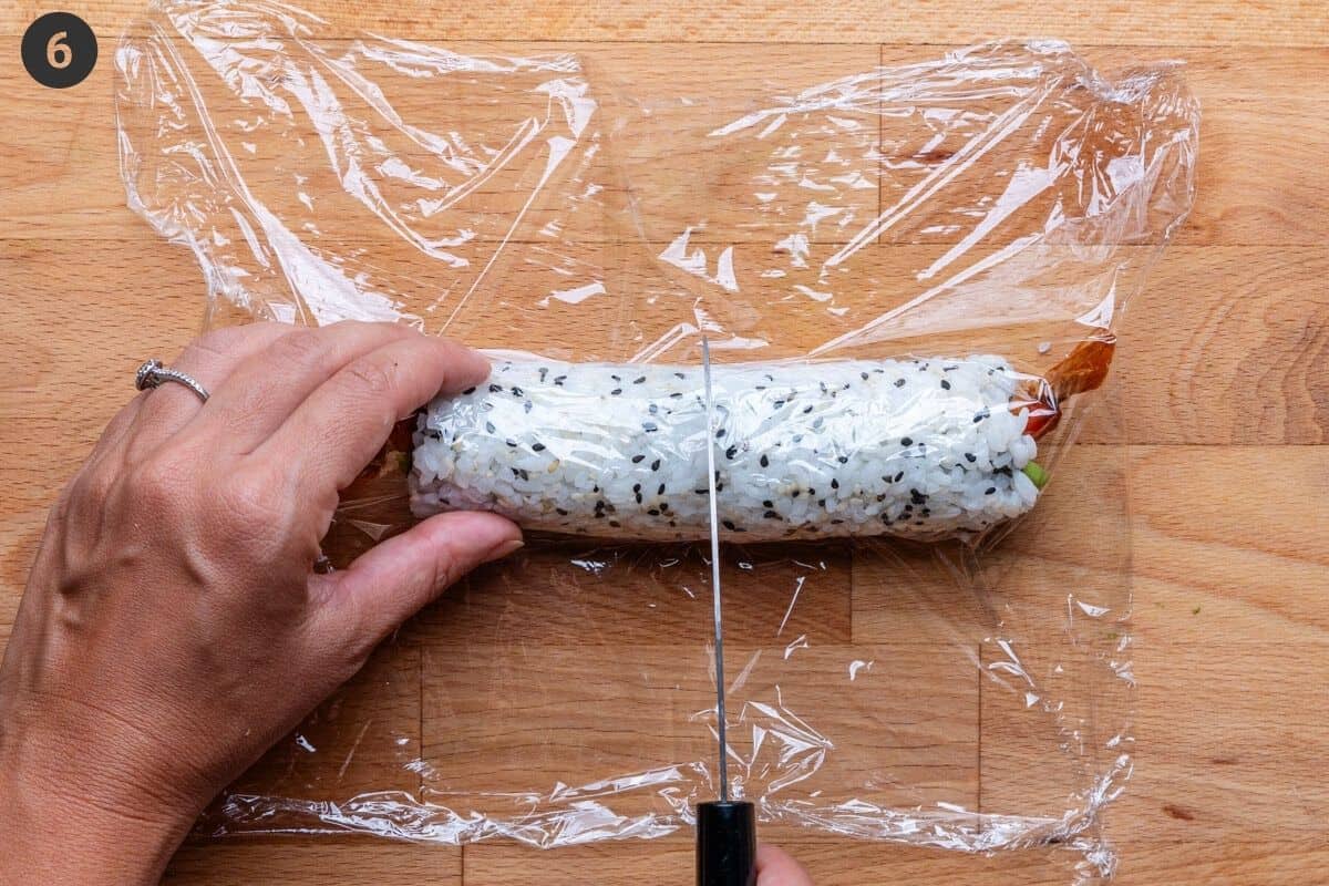 Cling wrap on sushi roll about to be cut