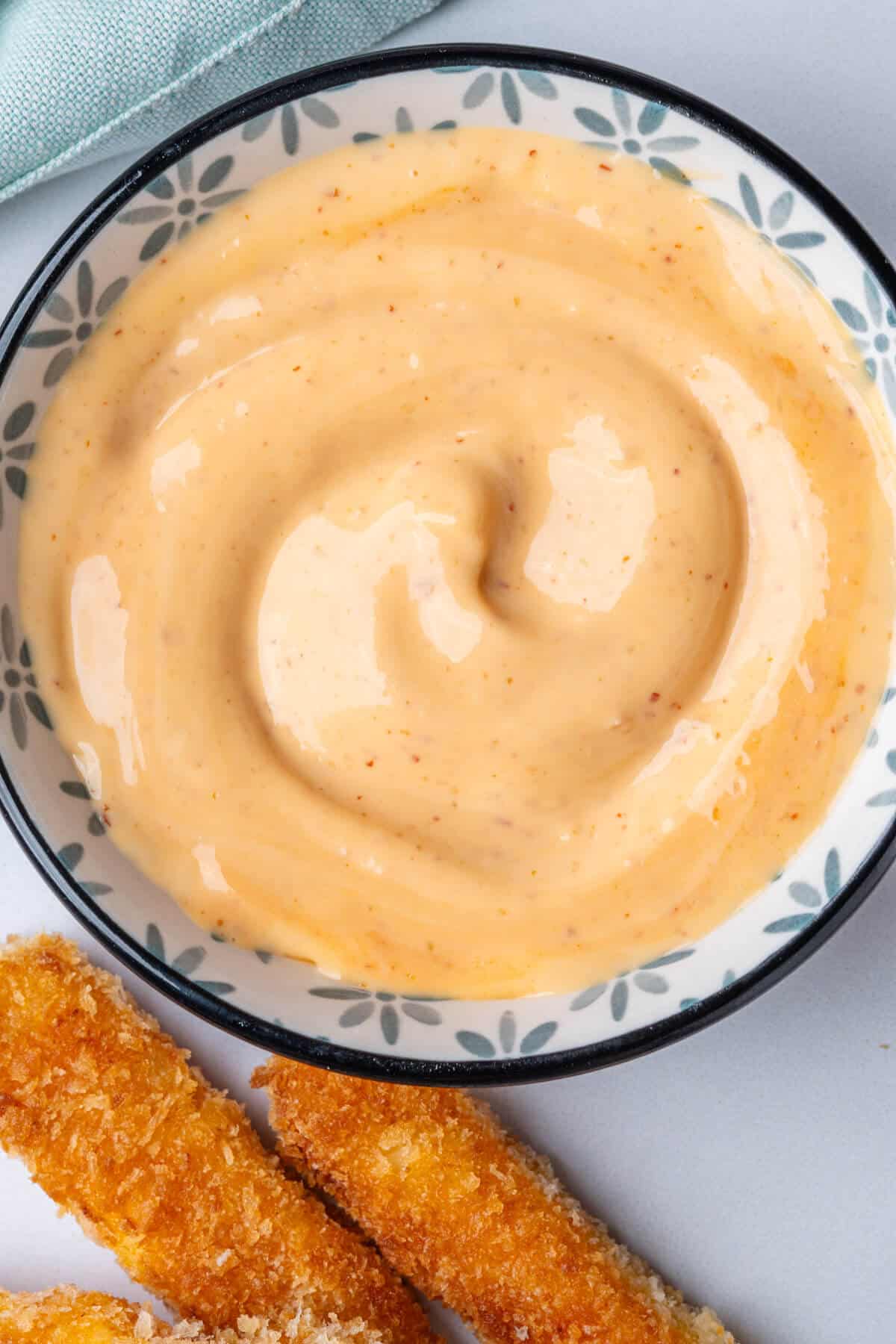 Spicy aioli in a bowl with halloumi fries on the side