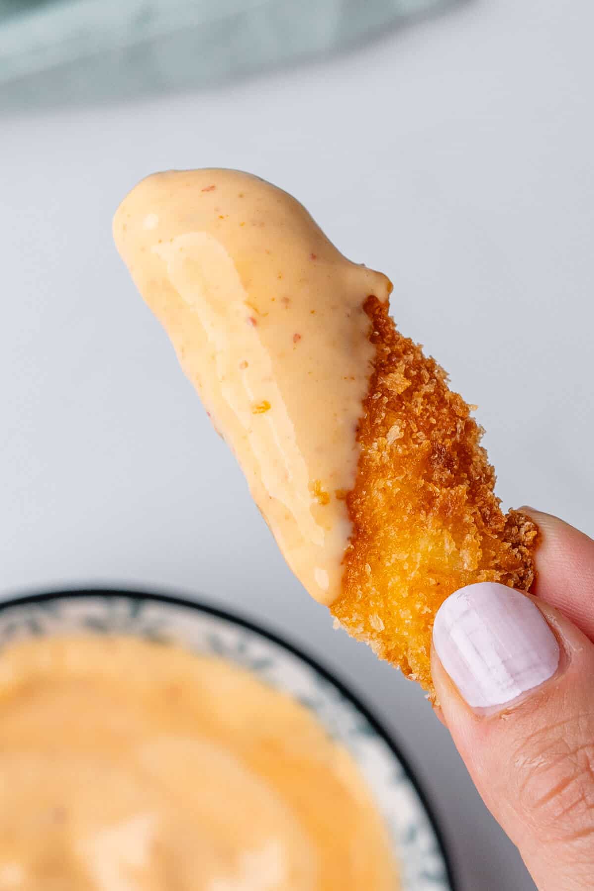 Close up of fry dipped into aioli