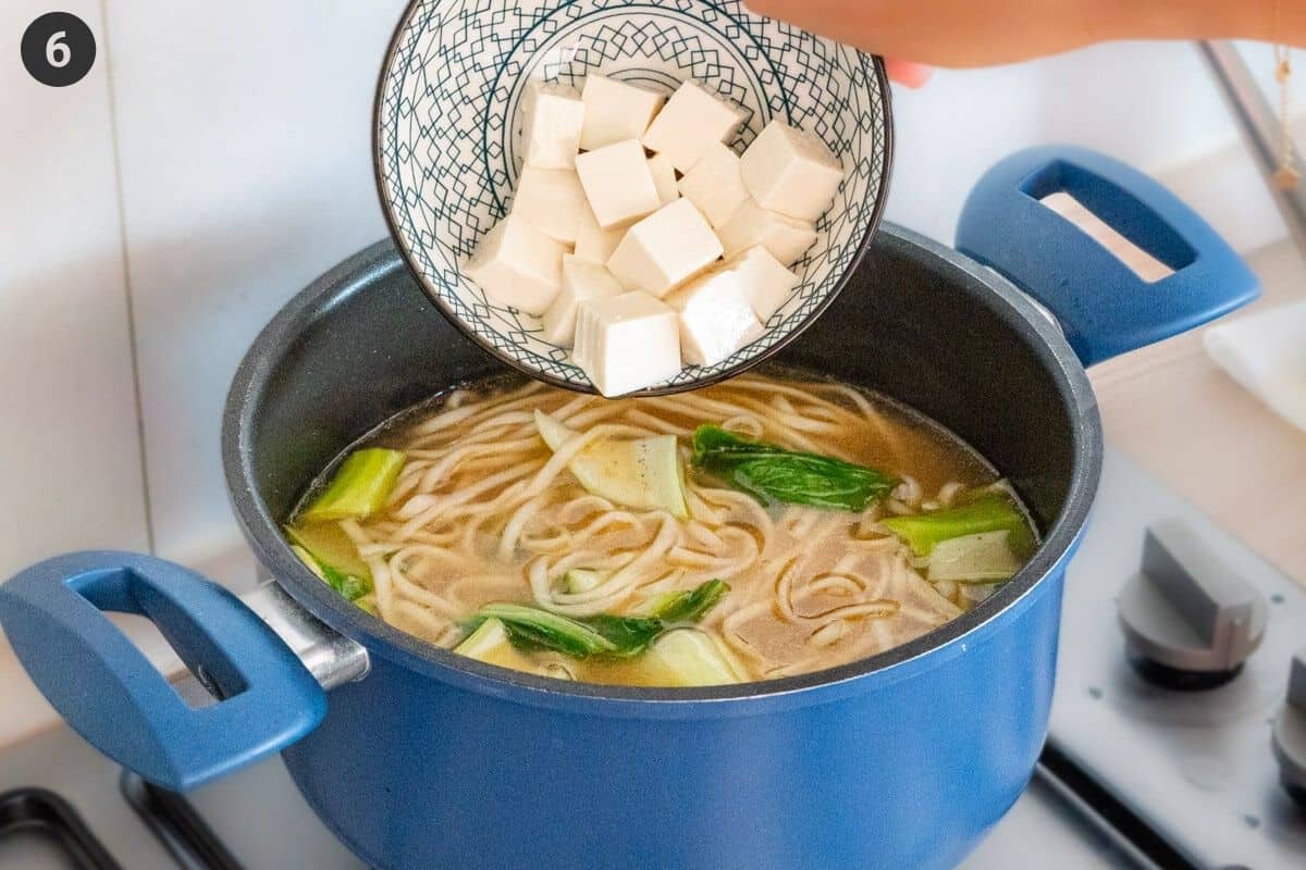 Silken tofu being added to a large pot