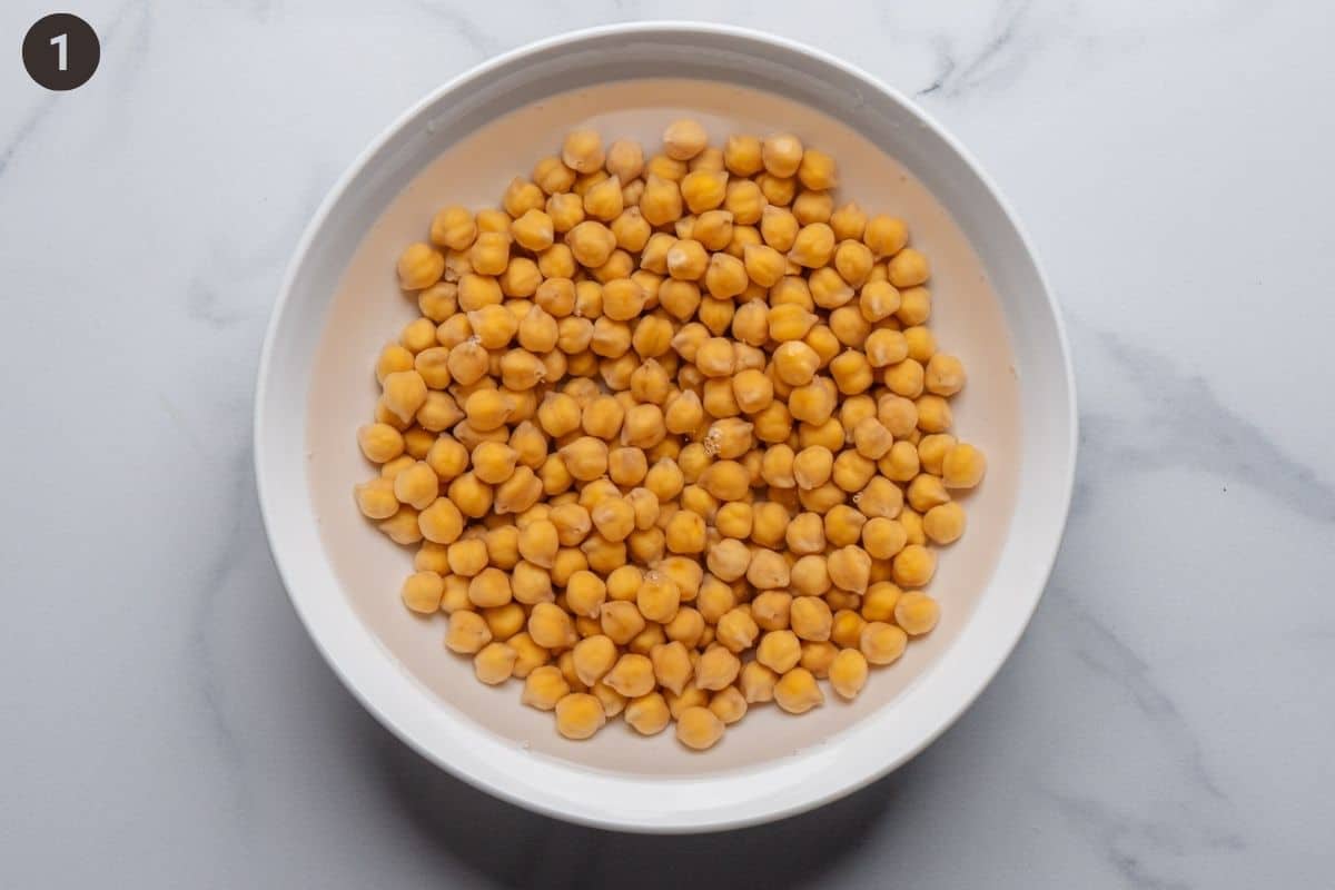 Raw chickpeas soaked in water in a bowl