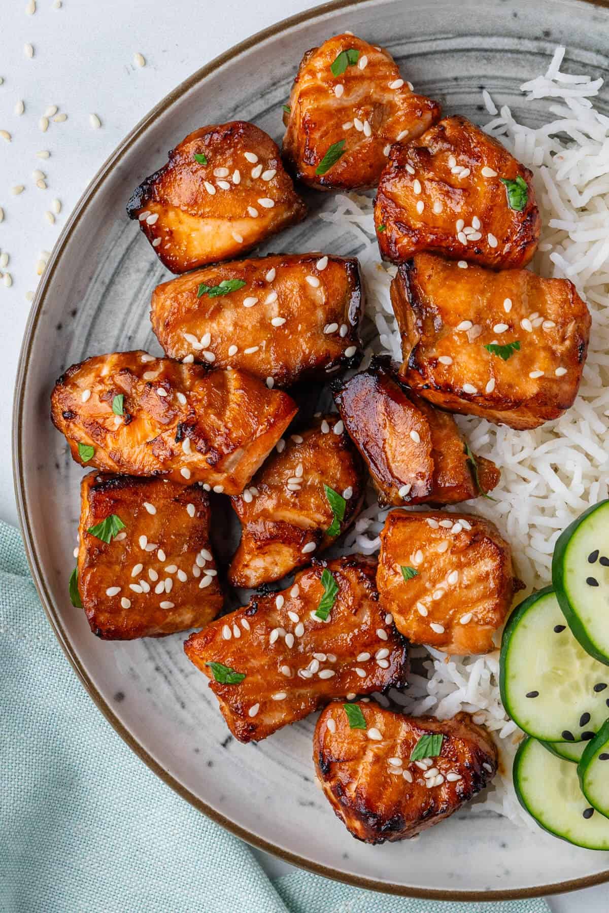 Air fryer salmon bites served with rice and cucumbers