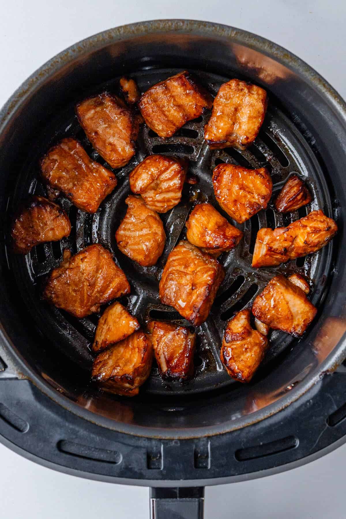 Cooked salmon bites in an air fryer basket