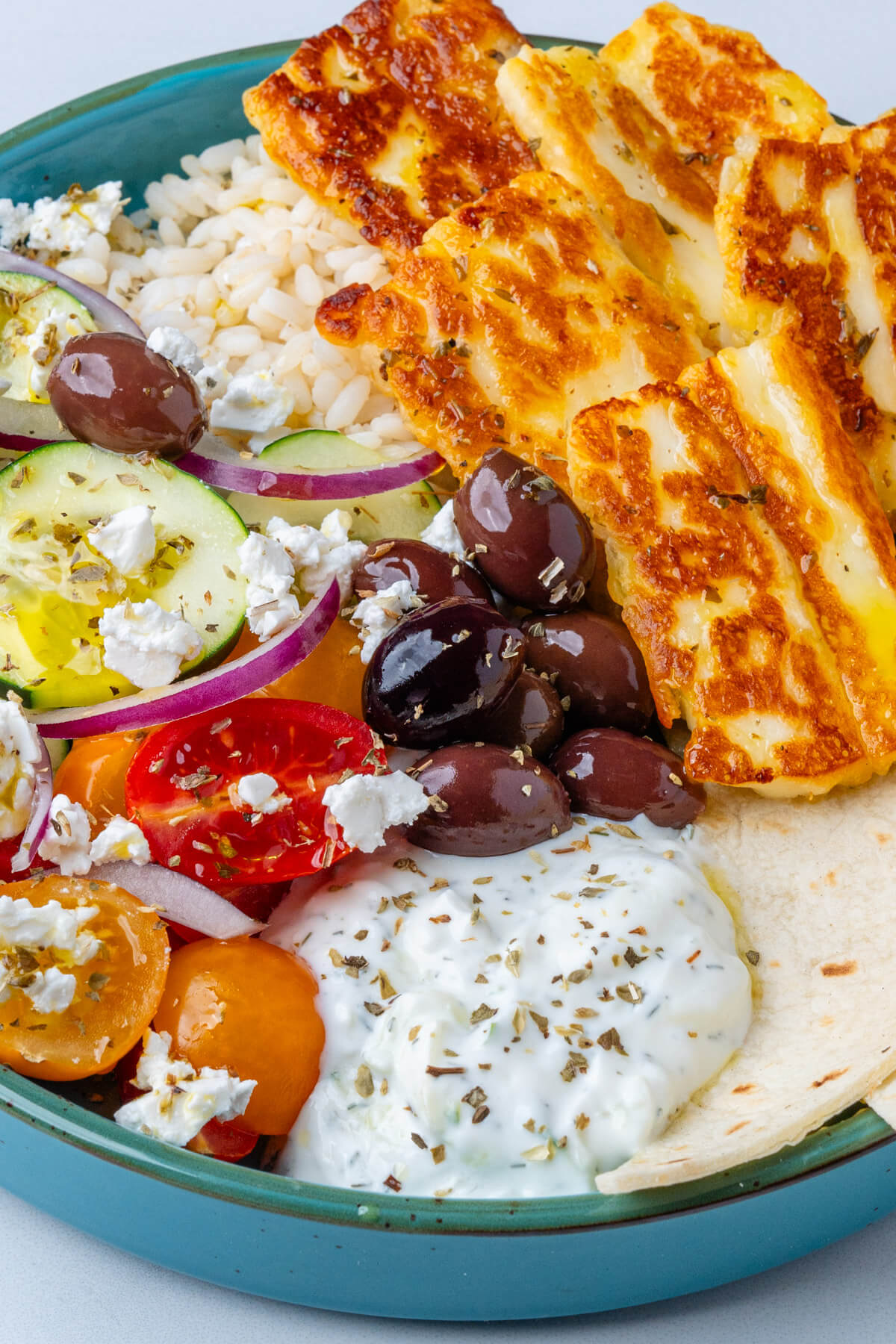 Greek bowl with olives, halloumi, salad, pita bread and tzatziki